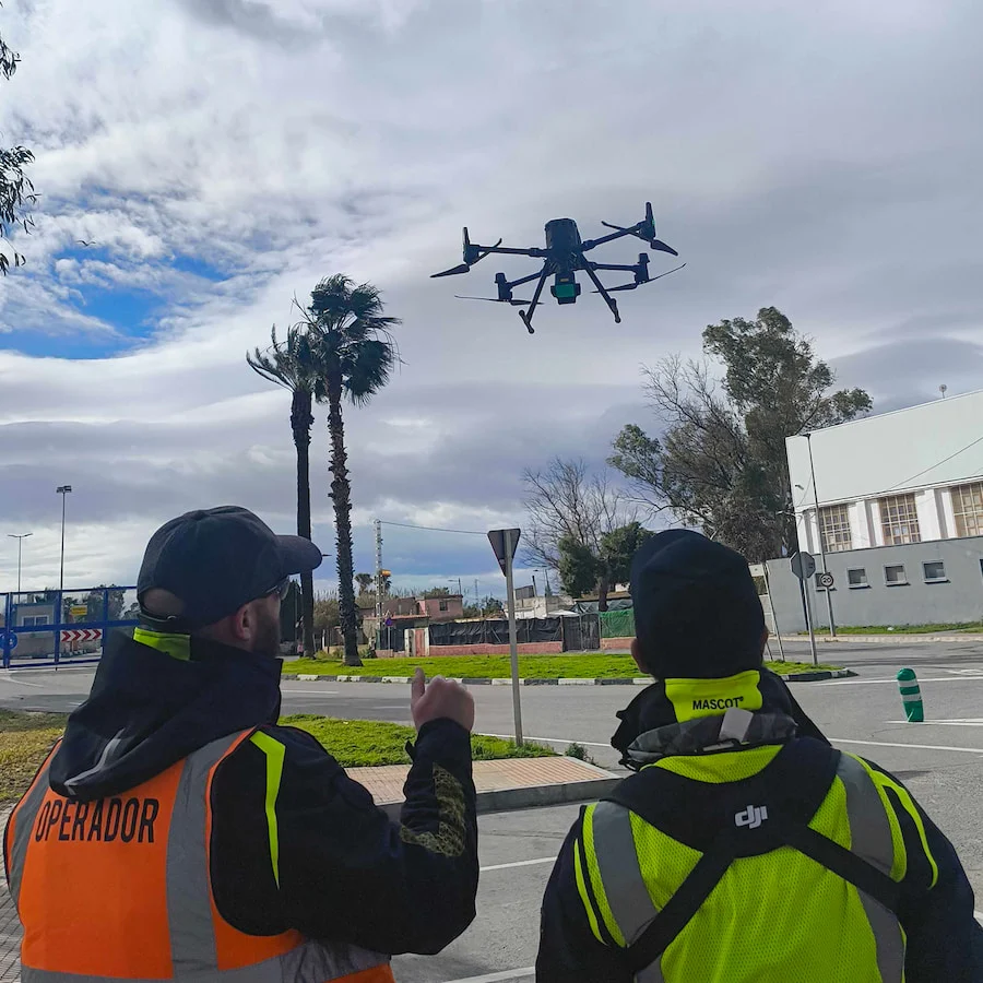 Drone operators flying a photogrammetry and infrastructure inspection mission on a construction site
